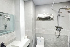 A modern bathroom with a glass shower enclosure, a white sink, and a towel rack. - Jiulong Holiday Hotel (Hami)