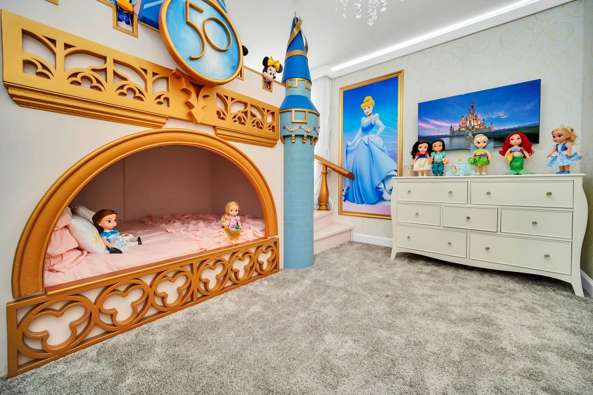 A child's bedroom with a castle-themed bed, a dresser, and Disney princess figurines.