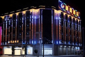 Un hotel de varios pisos con señalización iluminada y un diseño arquitectónico moderno.