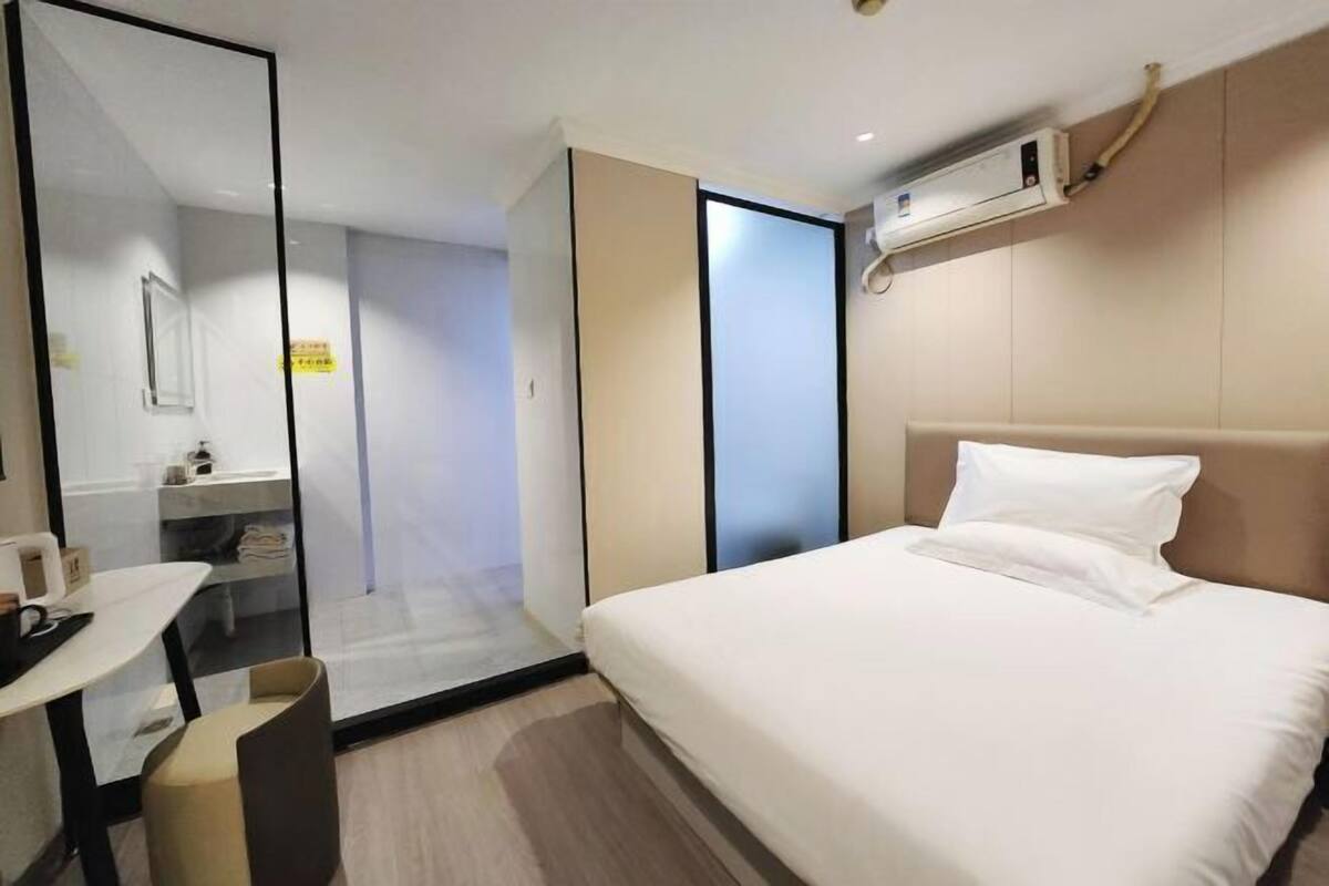 Une chambre d’hôtel avec un lit, un bureau et un miroir.