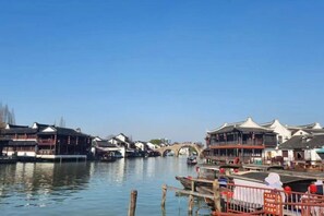 A riverside view with traditional buildings, a bridge, and boats. - Shanghai Jincheng Hotel (Zhujiajiao Ancient Town) (Shanghai)