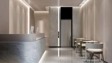 A modern hotel lobby with a reception desk, seating area, and a sleek, minimalist design.