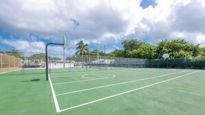 A tennis court with a net, surrounded by a fence and trees. - Keys Paradise! (Key Largo)