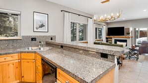 A modern kitchen with granite countertops, wooden cabinets, and a built-in dishwasher.