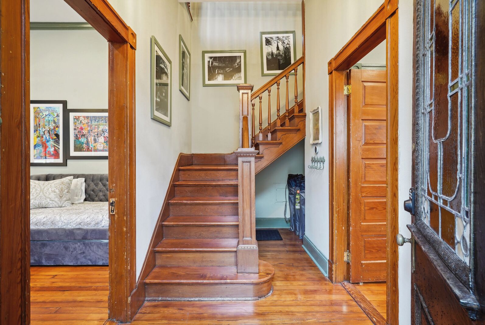 A wooden staircase leading to a bedroom with a bed and a framed picture on the wall.