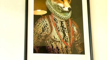 Une œuvre d’art encadrée représentant un renard, vêtu d’un costume élaboré et richement décoré.