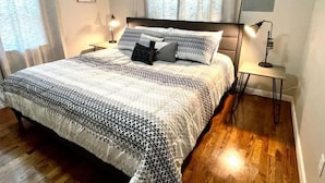 A neatly arranged bedroom with a large bed, two bedside tables, and a nightstand.