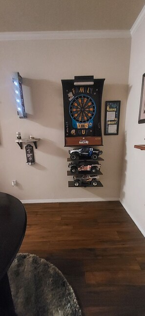 Relax in a room with a dartboard and a collection of model cars on display.