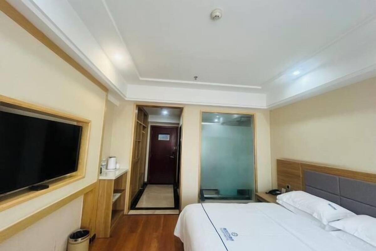 Une chambre d’hôtel avec un lit, une télévision, un bureau et une salle de bain.