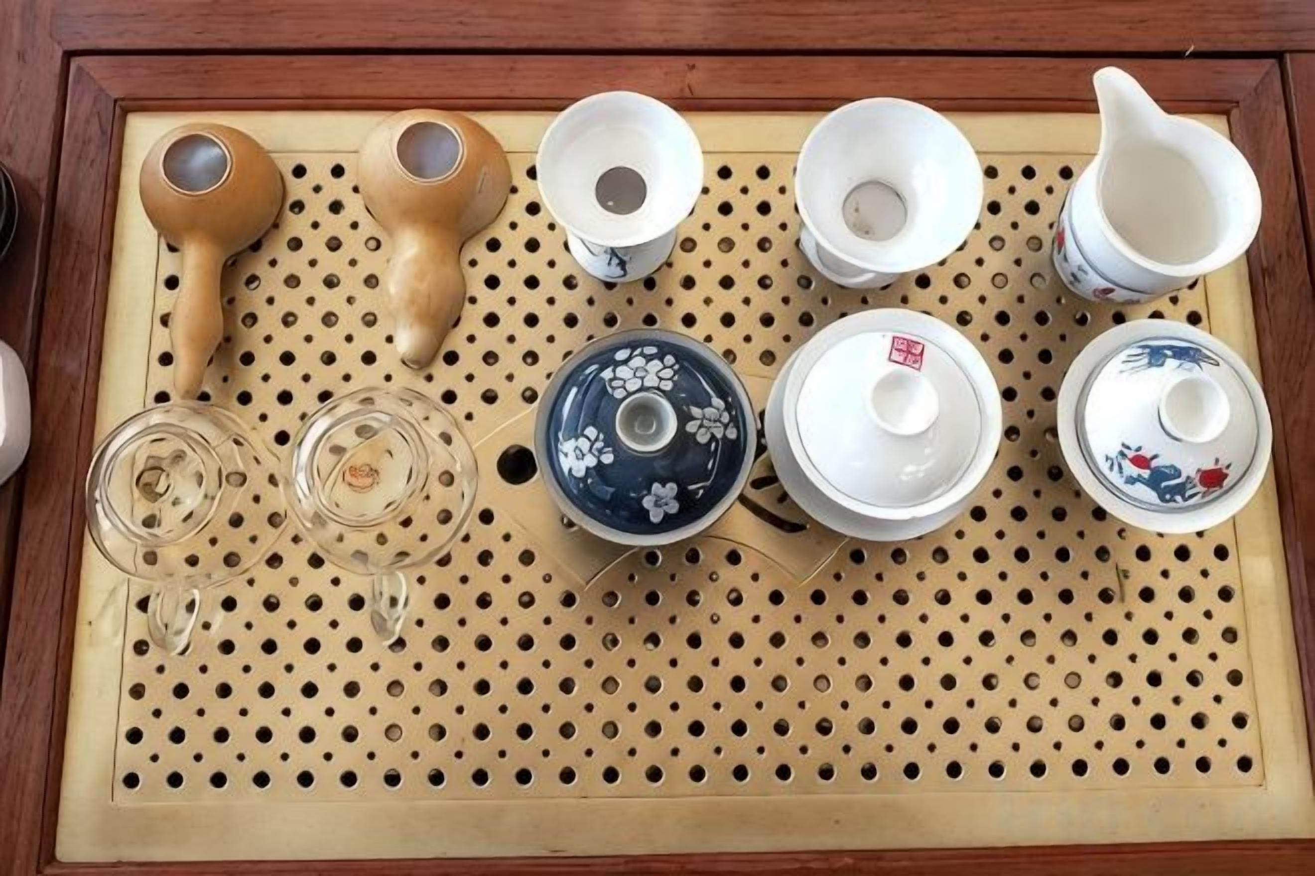 Una bandeja con diversos utensilios de cerámica para té y una tetera azul.