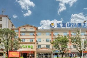 A hotel with multiple floors, a prominent sign, and a clear sky. - Pu'er 1974 Hotel (Si Lan Bei Store) (Pu'er)