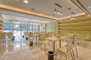 A spacious indoor area with tables and chairs arranged for dining, large windows allowing natural light, and a clean, modern design. - Pu'er 1974 Hotel (Si Lan Bei Store) (Pu'er)