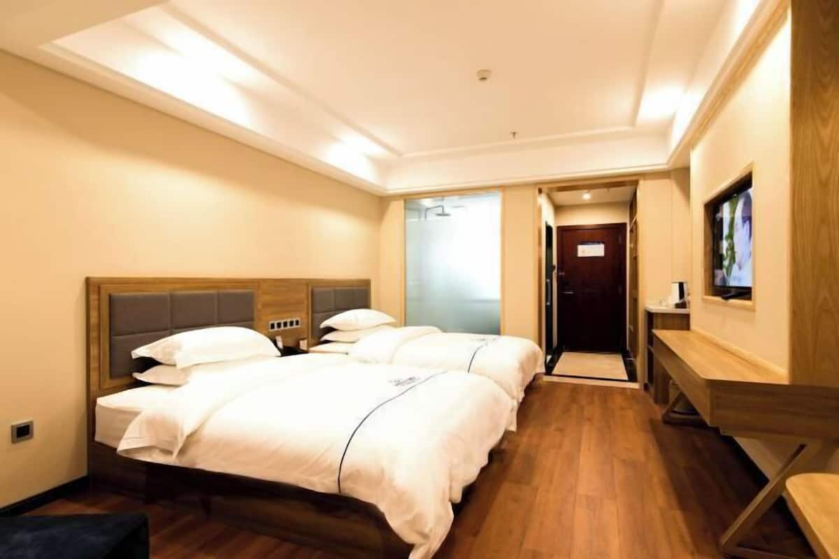 Une chambre d’hôtel avec un lit double, un bureau et une télévision.