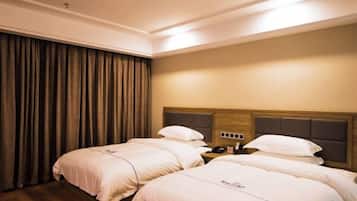 Una habitación de hotel con dos camas, un cabecero de madera, una mesita de noche y una cortina.