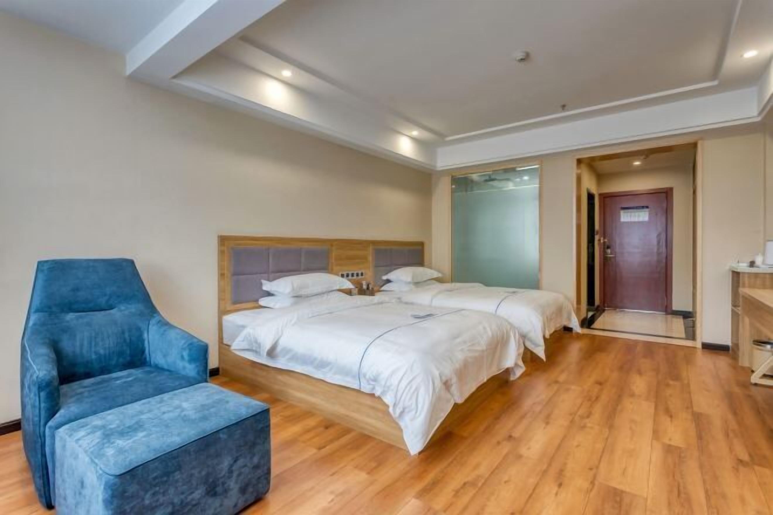 A hotel room with a bed, a chair, and a small table.