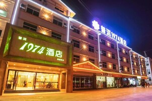 Un hotel con un llamativo letrero que dice '1974', varios pisos y ventanas iluminadas.