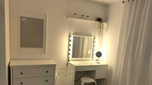 A small, clean bathroom with a vanity, mirror, and a stool. - One of a kind! Apartment with everything. (Toa Baja)