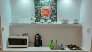 A compact kitchen with a microwave, coffee machine, sink, and a small refrigerator. - One of a kind! Apartment with everything. (Toa Baja)