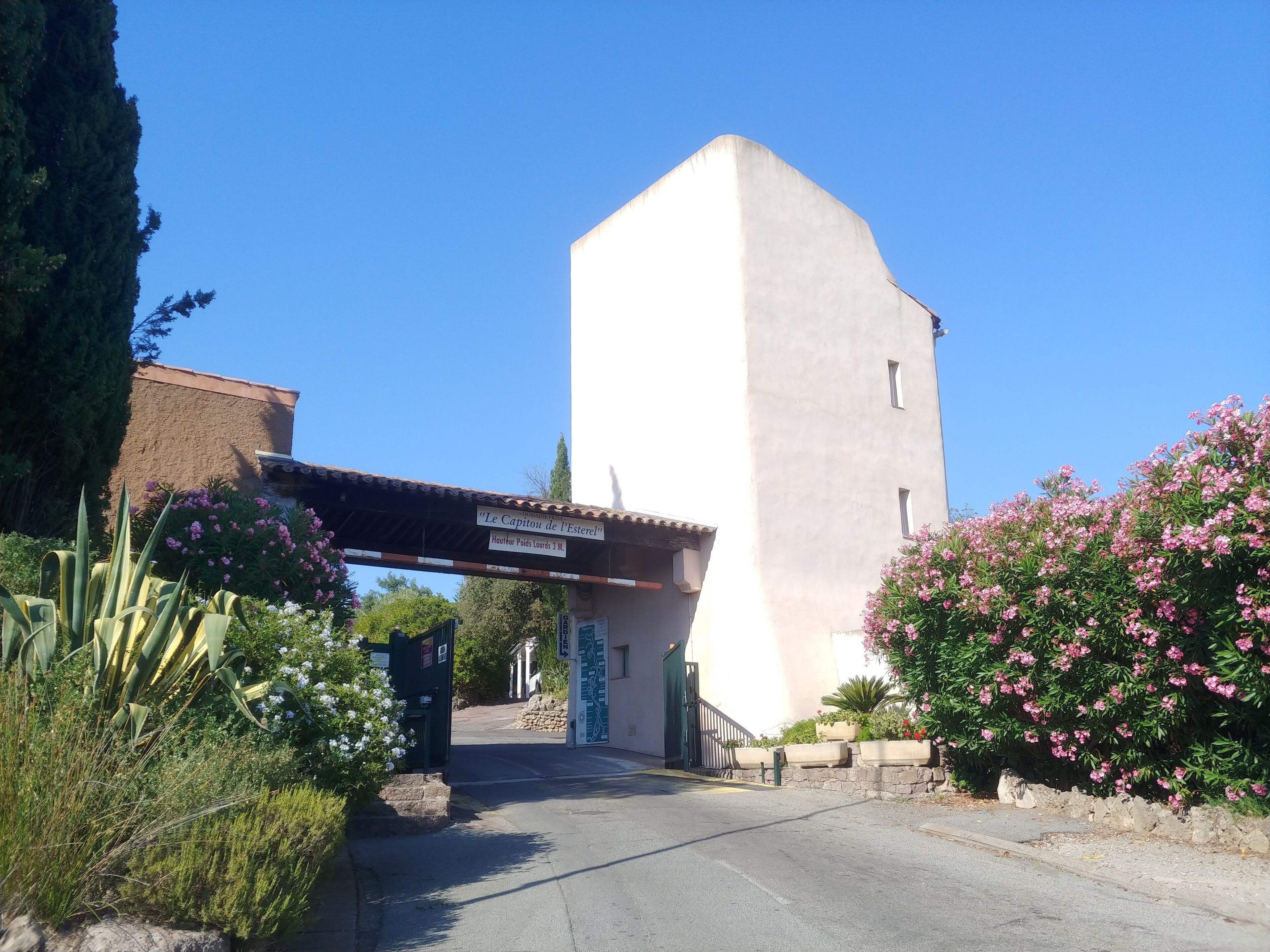 A building with a sign reading "Le Capitou de l'Esterel" and a road leading to it.