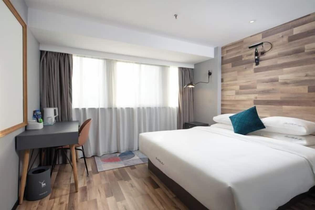 Ein Hotelzimmer mit Bett, Schreibtisch und Stuhl.