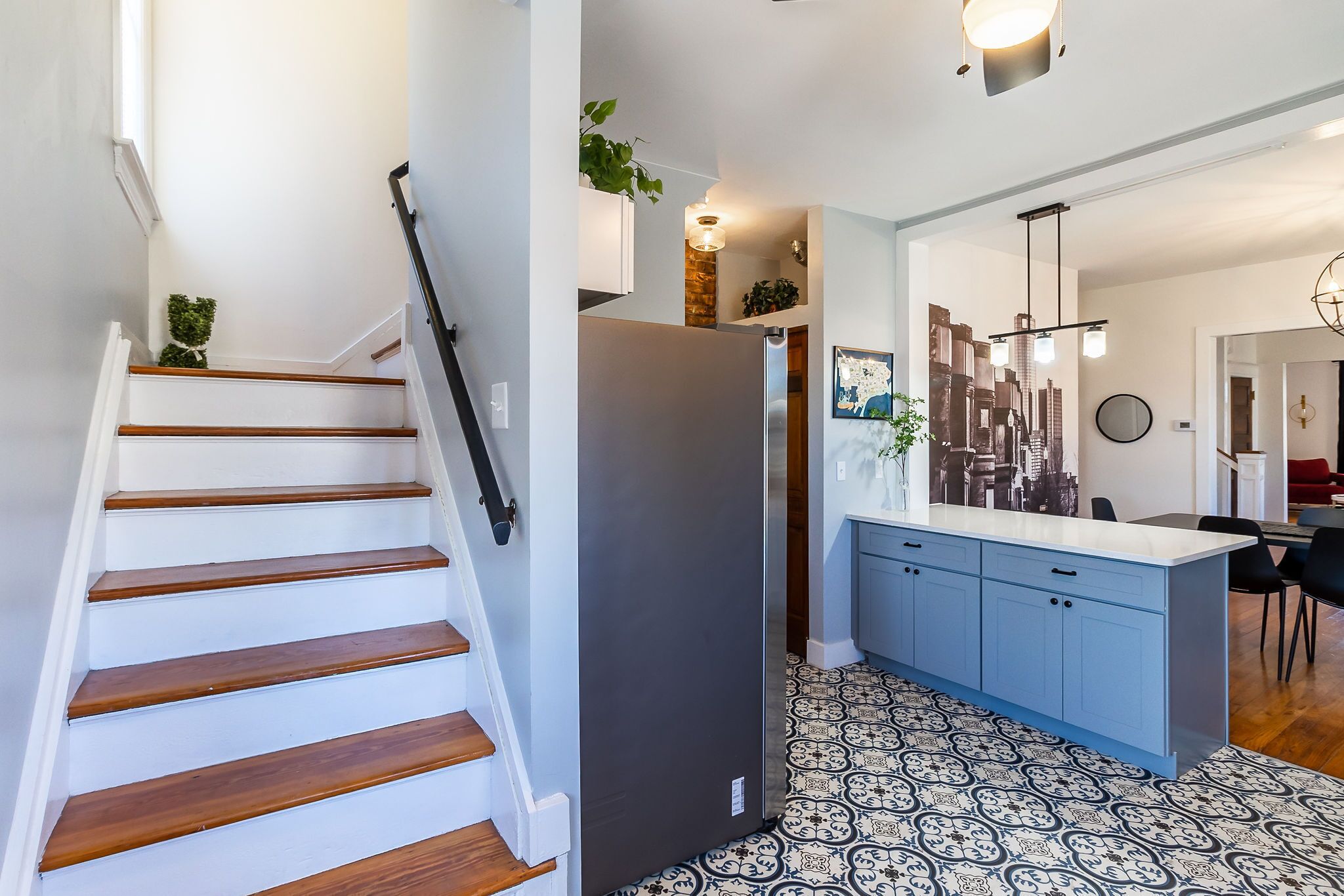 A modern kitchen with a central island, white walls, and patterned flooring.