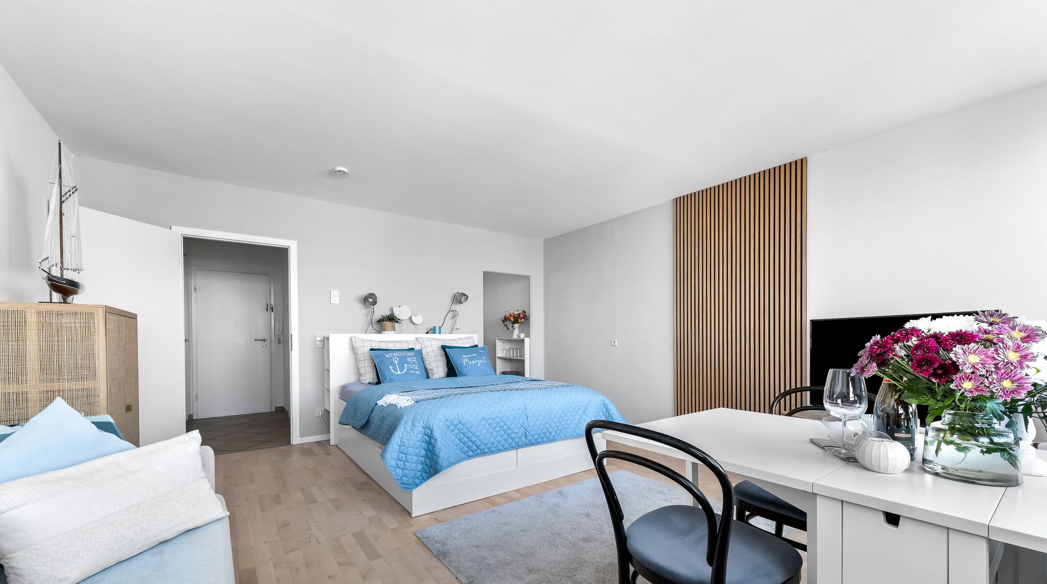 Ein modernes Schlafzimmer mit Bett, Nachttisch und Schreibtisch mit Stuhl.