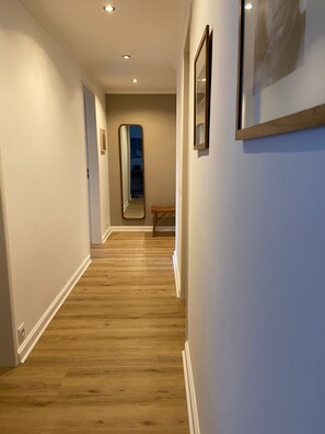 A hallway with wooden flooring, white walls, and recessed ceiling lights. - Peaceful 2 bd with ocean view in Monte Estoril (Estoril)