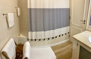 A bathroom with a bathtub, a shower curtain, a sink, and a mirror. - Peaceful 2 bd with ocean view in Monte Estoril (Estoril)