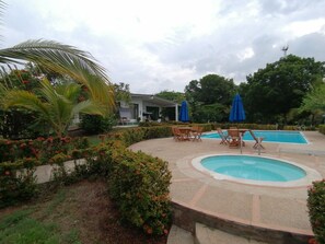 Relax by the pool surrounded by lush greenery and comfortable lounge seating.