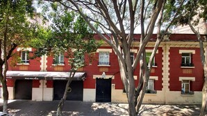 A red and white building with a black door and windows, surrounded by trees. - Acogedor y Amplio Departamento Roma Nte (Mexico City)