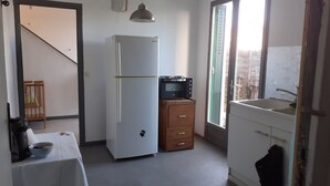 Une cuisine de taille réduite équipée d’un réfrigérateur, d’un four à micro-ondes et d’un meuble en bois.