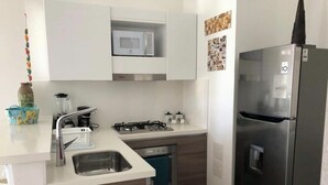 Una cucina moderna con frigorifero in acciaio inossidabile, forno a microonde, piano cottura e lavastoviglie.