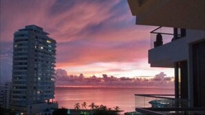 Un grattacielo con vista sull'oceano al tramonto.