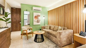 Una sala de estar moderna con un sofá, una mesa de centro redonda, una lámpara y un revestimiento de pared de madera.