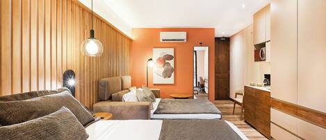 A hotel room with a bed, a sofa, a desk, and a chair.