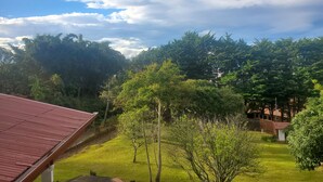 A view of a residential area with a red-roofed building, lush greenery, and a clear sky. - Romantic Rustic Villa in the Mountains 30 Minutes from The  airport . (Barva)