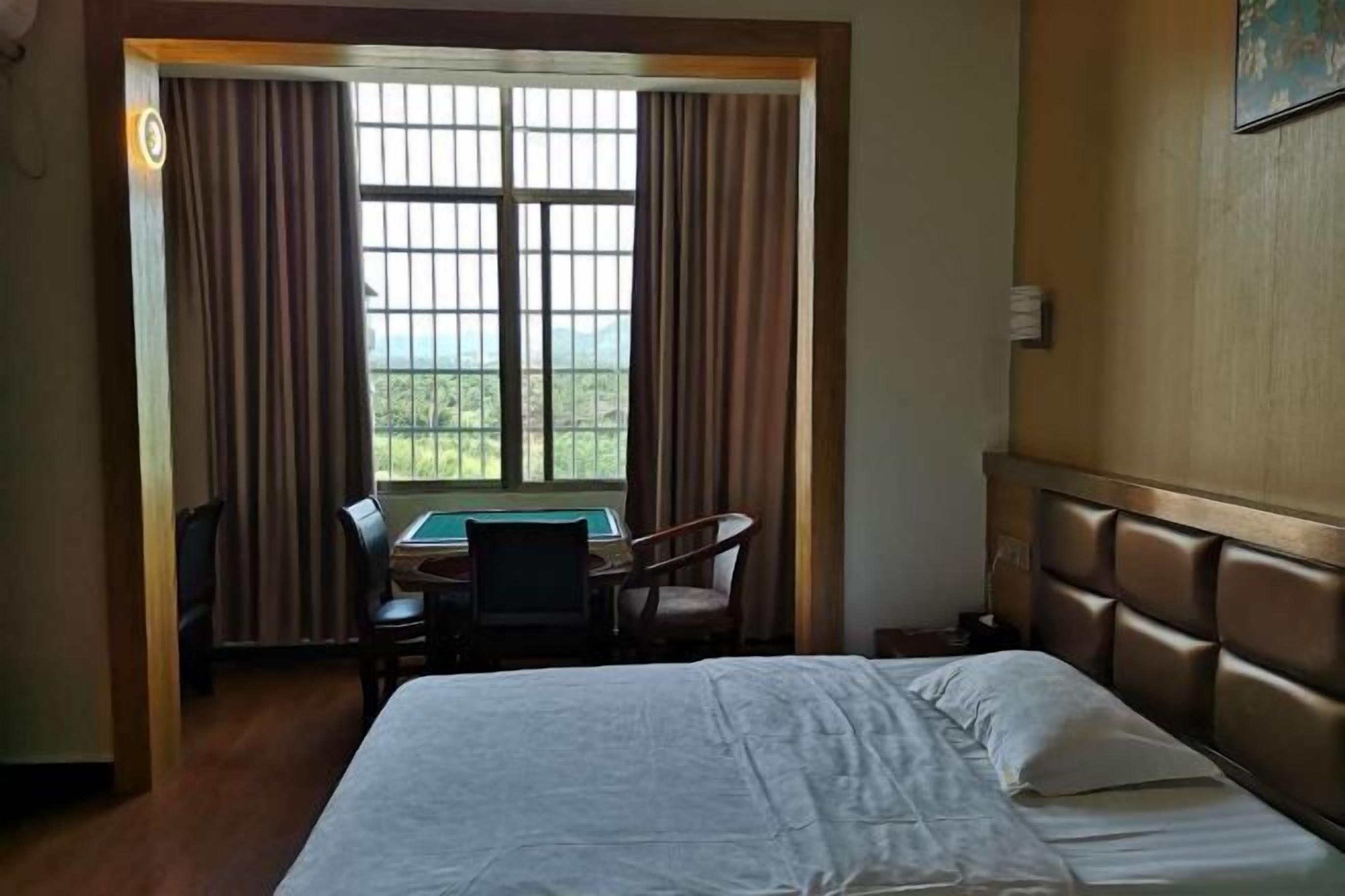 Ein Hotelzimmer mit Bett, Schreibtisch und Blick ins Freie.