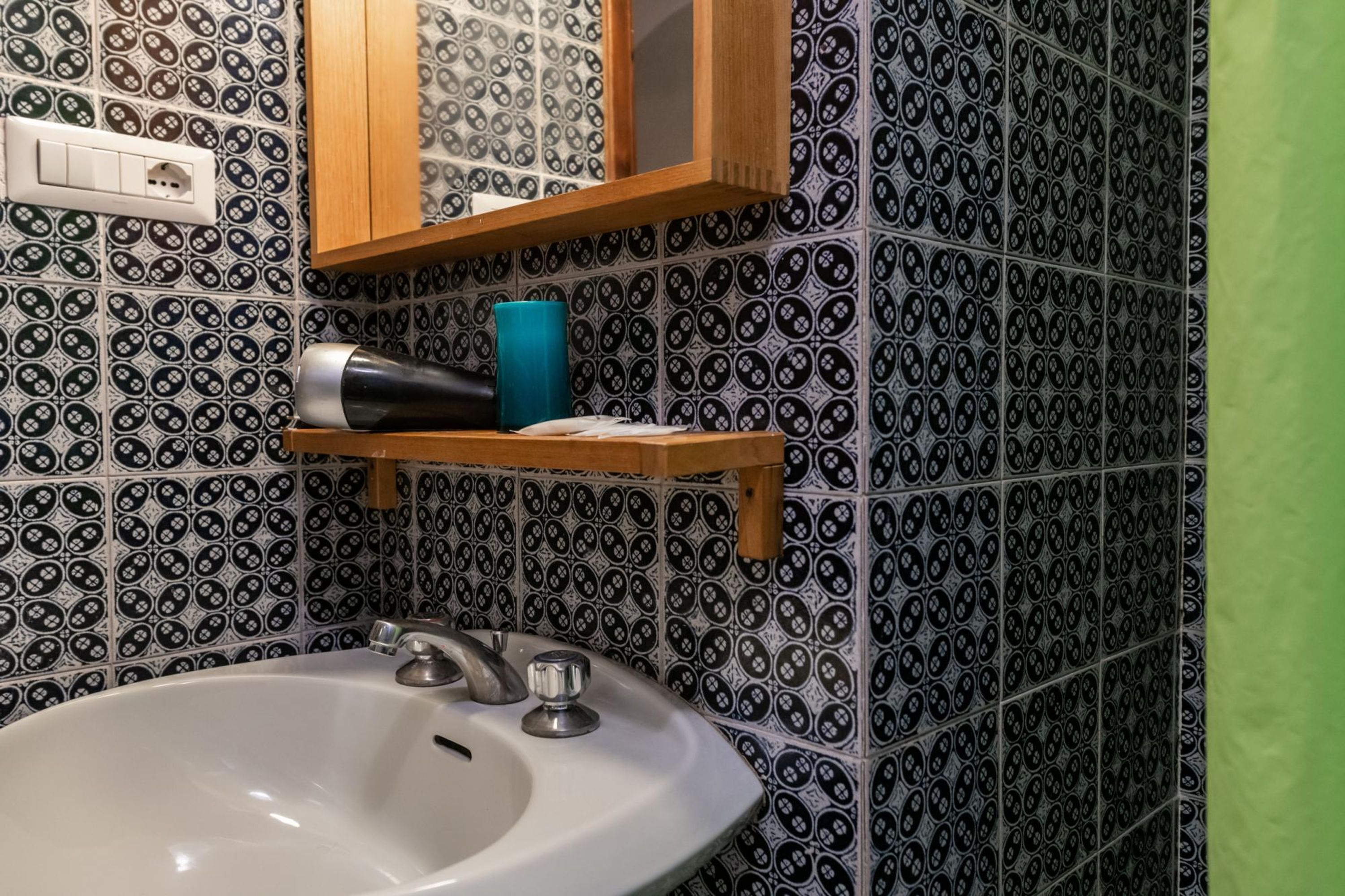 A bathroom with a white sink, a mirror, and a towel rack.