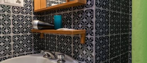 A bathroom with a white sink, a mirror, and a towel rack.