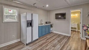 A kitchen with a refrigerator, blue cabinets, and a microwave. - Gone Fishing on Lake Wateree (Liberty Hill)