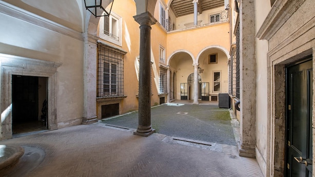 A courtyard with a fountain, columns, and a door. - Banchi Nuovi - Castel Sant Angelo (Rome)