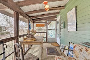 Une pièce chaleureuse avec une table en bois, des chaises, un tapis à motifs et une carte accrochée au mur.