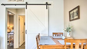 Ein Essbereich mit Holztisch, Stühlen und einer Schiebetür im Bauernhausstil.