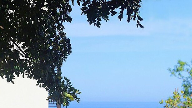 An outdoor dining area with blue chairs and a table set for two, overlooking a scenic view of the sea. - Villa with swimming pool with spectacular sea views and Mediterranean vegetation (Sicilia)