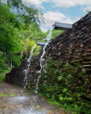 A stone wall with a waterfall cascading down. - Viver Hotel Fazenda Property (Moreno)