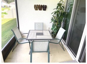 Enjoy a peaceful retreat on this balcony with a table for two and a lush view.