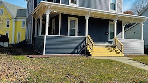 A two-story house with a porch and a staircase. - Triple Play Apt 2 - All Star Baseball Rentals (Oneonta)