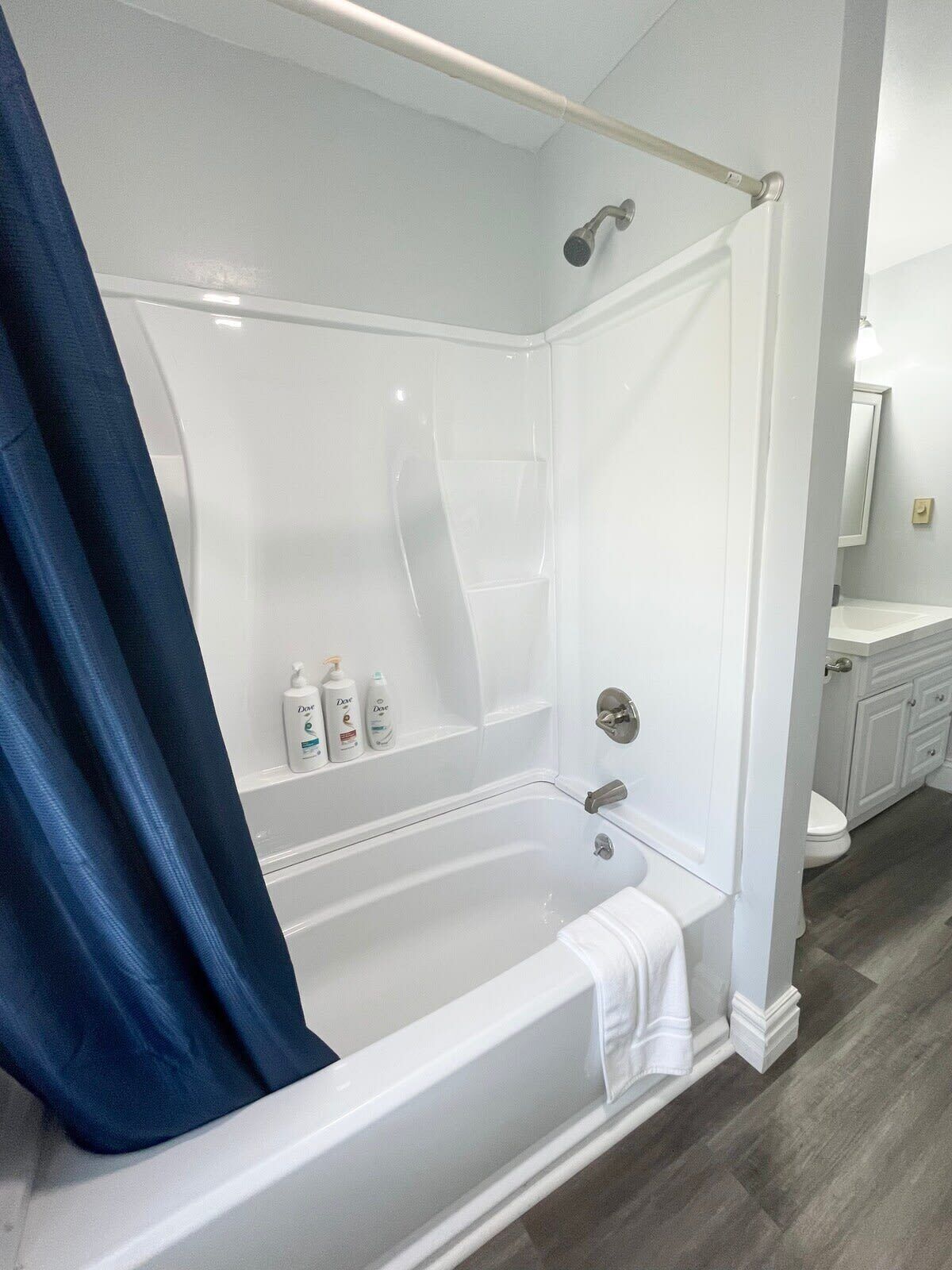 A modern bathroom with a white bathtub, a shower, and a vanity with a mirror.