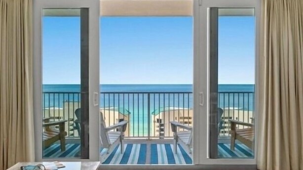 A balcony with a view of the ocean, featuring two chairs and a table. - “Just Breathe”It’s all about the view & location! Sleeps 7.  (Panama City Beach)