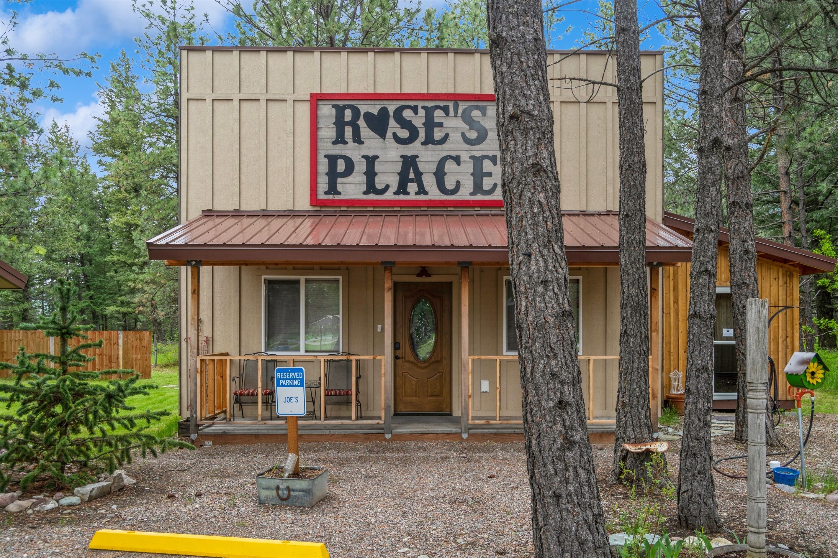 A building with a sign reading "ROSE'S PLACE" and a reserved parking sign for "JOE'S".